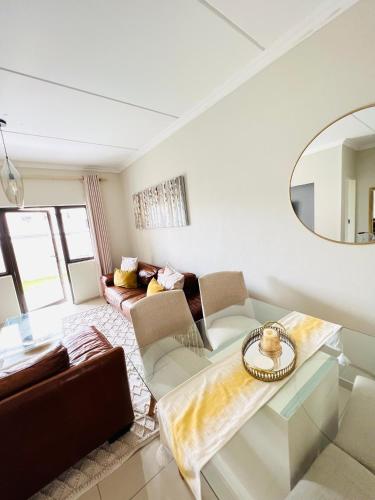 a living room with a couch and a mirror at The Escape Haven in Sandton
