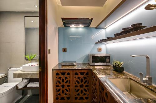 a bathroom with a sink and a microwave on a counter at Halina Hotel and Apartment in Da Nang