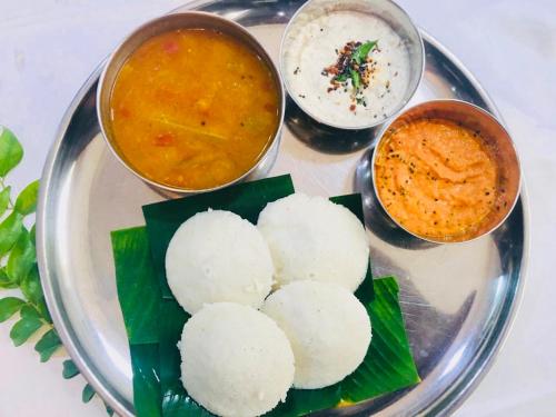 a plate of food with rice and two bowls of food at Chandragiri Heritage Bungalow and Cottages in Vaduvanchal