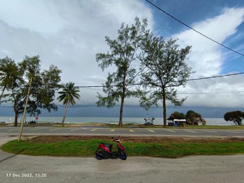 a red motorcycle parked on the side of a street at Seaview Promenade Homestay Dungun in Dungun