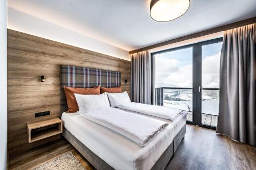 1 dormitorio con cama grande y ventana grande en Nativo Bergaparts en Längenfeld