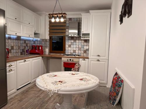 a kitchen with white cabinets and a white table at Apartament English Home 2 camere Brasov in Braşov