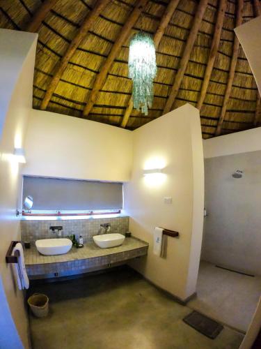 a bathroom with two sinks and a chandelier at The Makokola Retreat in Mponda