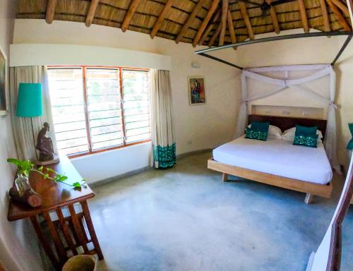 a bedroom with a bed and two windows at The Makokola Retreat in Mponda