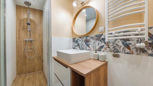 La salle de bains est pourvue d'un lavabo et d'un miroir. dans l'établissement Apartament Studio z parkingiem 22 C Perłowa Przystań - Holiday City, à Kołobrzeg