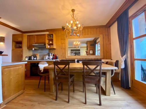 une cuisine avec une grande table et des chaises en bois dans l'établissement Chalet Mont Blanc - Arc 1950 - Ski-in Ski-out, 2 bed duplex, sleeps 8, à Bourg-Saint-Maurice