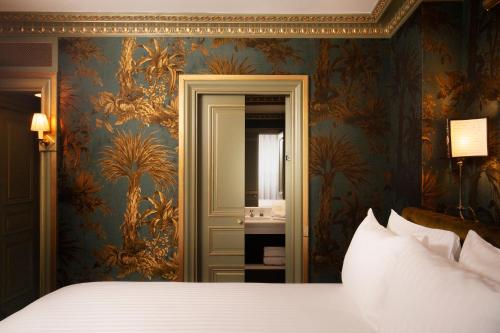 a bedroom with a bed and a mirror at Maison Proust, Hotel & Spa La Mer in Paris