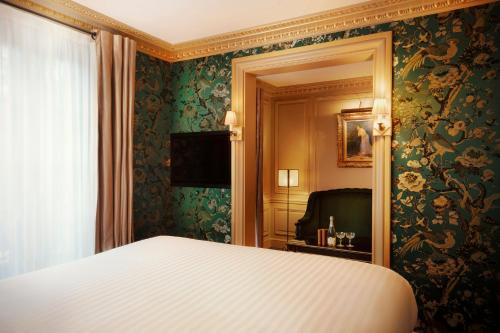 a bedroom with a bed and green floral wallpaper at Maison Proust, Hotel & Spa La Mer in Paris