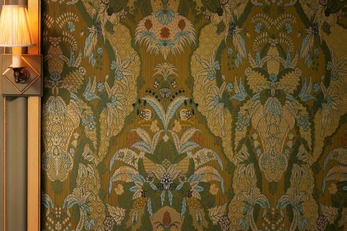 a wall with a floral wallpaper with a lamp at Maison Proust, Hotel & Spa La Mer in Paris