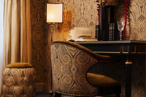 a chair in front of a desk with a lamp at Maison Proust, Hotel & Spa La Mer in Paris