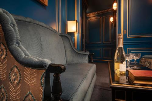 a living room with a couch and a bottle of wine at Maison Proust, Hotel & Spa La Mer in Paris