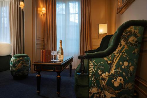 a room with a chair and a table with a wine bottle at Maison Proust, Hotel & Spa La Mer in Paris