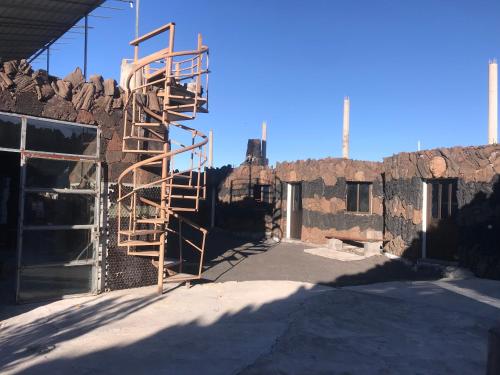 a ladder is on the side of a brick building at Pensão Repouso Alegre Turismo e Aventura in Portela