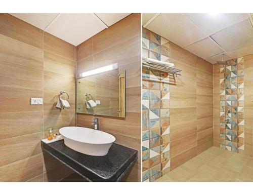 een badkamer met een wastafel en een spiegel bij Hotel Paras Inn, Lucknow in Lucknow