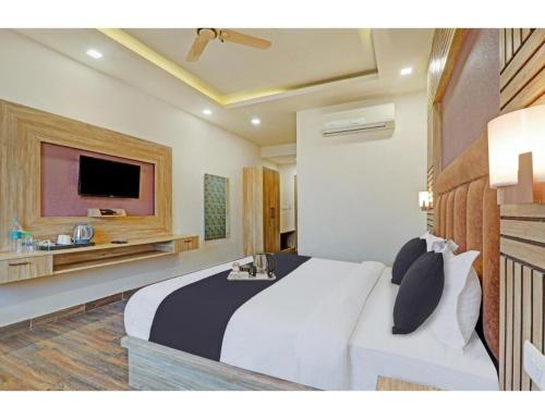 een slaapkamer met een groot bed en een televisie bij Hotel Paras Inn, Lucknow in Lucknow