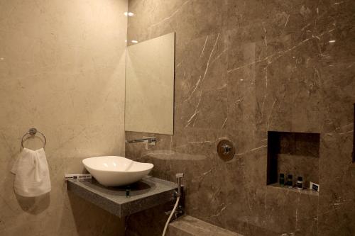 a bathroom with a sink and a mirror at The Presidential Suites in Bhuj