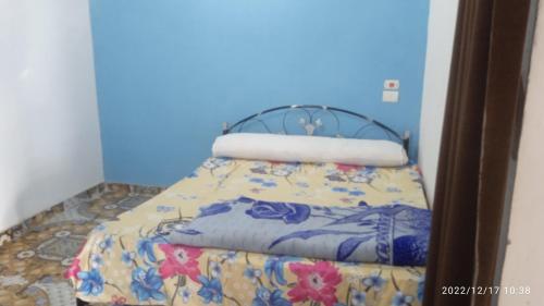 a bed in a room with a blue wall at Al Salam Camp in Luxor