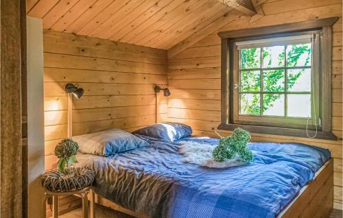 a bed in a wooden room with a window at 3 Bedroom Stunning Home In Rheezerveen in Rheezerveen