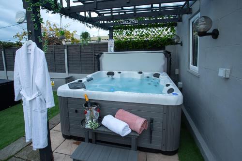 a jacuzzi tub in a backyard with a pergola at Wavecrest Cottage - Characterful 3 Bedroom Holiday Cottage in Flamborough