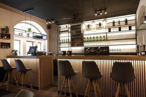 un bar con 4 sillas y una barra con botellas de vino en Bella Casa en Mnichovo Hradiště