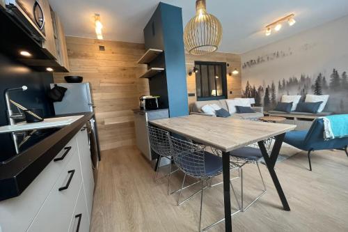 Il comprend une cuisine et un salon avec une table et des chaises. dans l'établissement IMMOGROOM - Total renovation 2023 - At the foot of the slopes - Wifi -, à Tignes