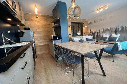 eine Küche und ein Wohnzimmer mit Tisch und Stühlen in der Unterkunft IMMOGROOM - Total renovation 2023 - At the foot of the slopes - Wifi - in Tignes