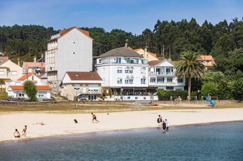 a group of people playing on the beach at Playa de Camariñas in Camariñas