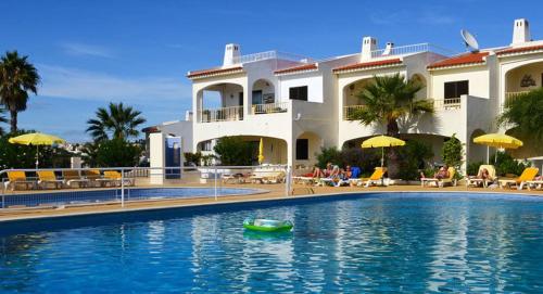 una piscina con un barco verde frente a una casa en Luxury Apartment, en Carvoeiro