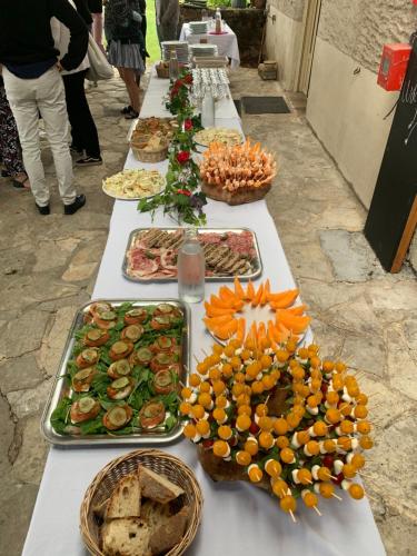 Ô MARRONNIER de NADAILLAC في Nadaillac: طاولة طويلة مع العديد من أطباق الطعام عليها