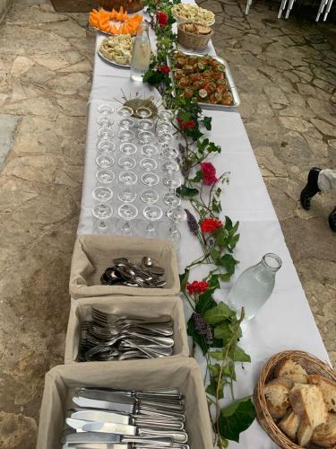 Ô MARRONNIER de NADAILLAC في Nadaillac: طاولة بيضاء طويلة مع أكواب وأطباق من الطعام