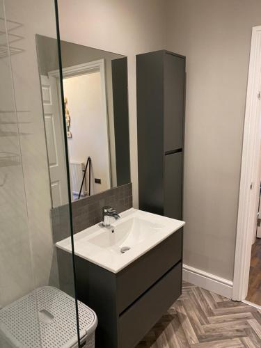 a bathroom with a sink and a toilet and a mirror at The Fort Lytham St Annes in Lytham St Annes