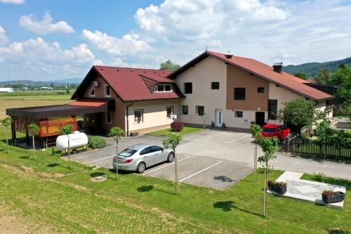 a house with a car parked in a parking lot at Lux Living Apartments BUDIČ near Terme Čatež in Brežice