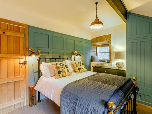 a bedroom with a bed and a green wall at Hob Cote in Heptonstall
