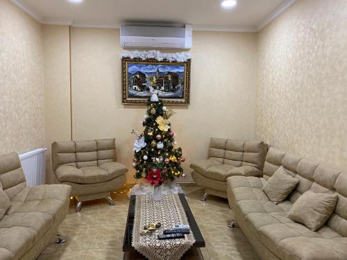 a living room with a christmas tree in a room at Hotel LU-MA in Tbilisi City