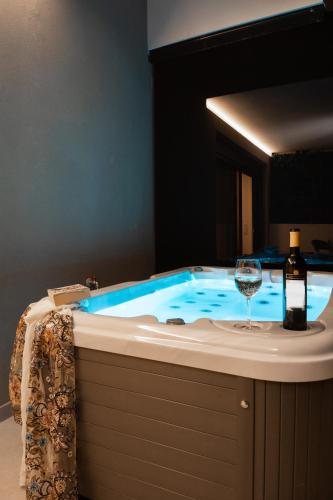 a hot tub with a bottle of wine and a wine glass at Incanto Boutique Suites - Neos Kosmos in Athens