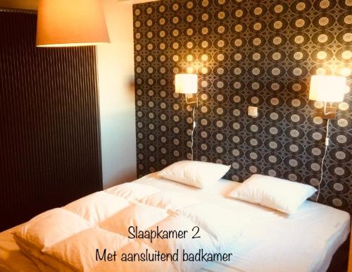 um quarto com uma cama e duas luzes na parede em Dolce Vita - zonnig familie appartement met garagebox em Nieuwpoort