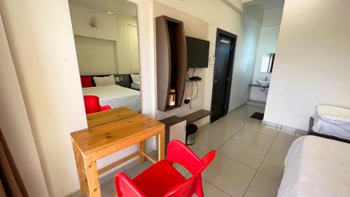 a room with red chairs and a table and a bed at The Gir Harmony Hotel in Sasan Gir