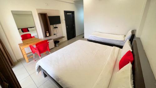 a room with two beds and a table and a desk at The Gir Harmony Hotel in Sasan Gir