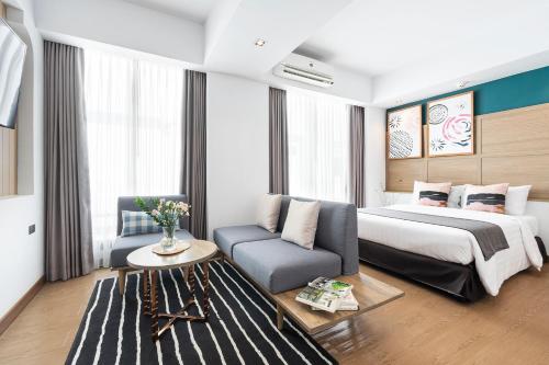 Darley Hotel Chiangmai في شيانغ ماي: غرفه فندقيه بسرير واريكه