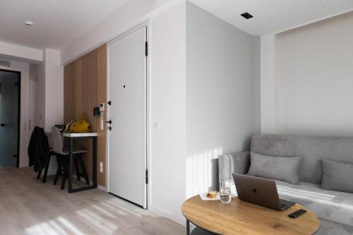 a living room with a couch and a laptop on a table at Incanto Boutique Suites - Neos Kosmos in Athens