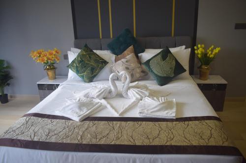 Una cama con sábanas blancas y cisnes. en Star Luxury Suites KLCC, en Kuala Lumpur