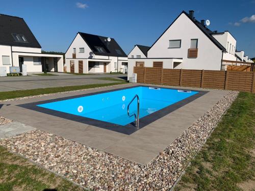 a swimming pool in front of some houses at Familienferienhaus Lilja - polnische Ostsee in Trzęsacz
