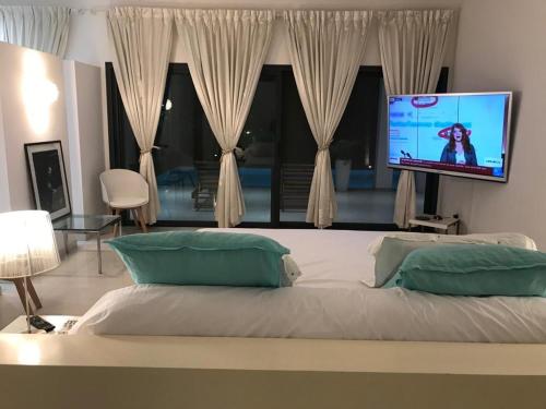 sypialnia z dużym łóżkiem i telewizorem z płaskim ekranem w obiekcie Villa Carabane w mieście Somone