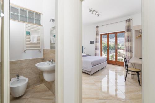 a bathroom with a sink and a bed in a room at Parsano Suite in Sorrento