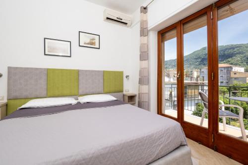 a bedroom with a bed and a large window at Parsano Suite in Sorrento