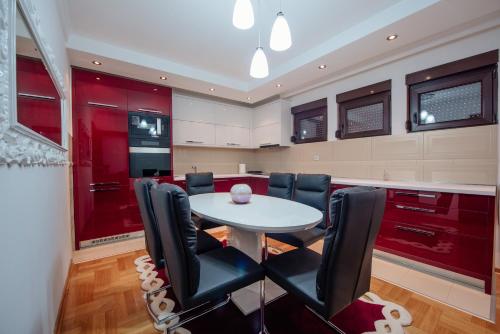a kitchen with a white table and black chairs at Loft2 in Kolašin