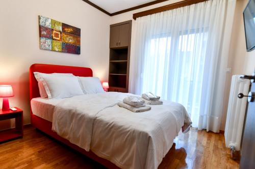 a bedroom with a bed with a red headboard and a window at Friendly Flat 1 in Edessa