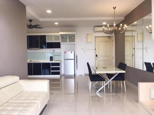 eine Küche und ein Wohnzimmer mit einem Tisch und einem Sofa in der Unterkunft Nice Podium View @Atlantis Melaka in Malakka