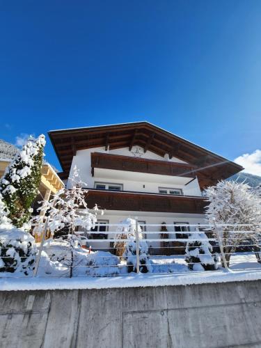 a building covered in snow with trees in front of it at Haus Gabriele in Gaschurn