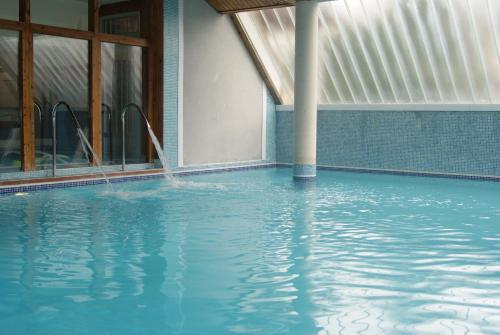 a swimming pool with water coming out of the windows at Hotel Ría de Suances in Suances